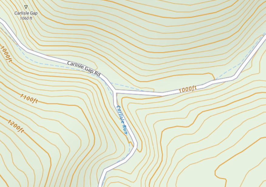 Contour lines descending in elevation to a road and intermittent stream on a topo map